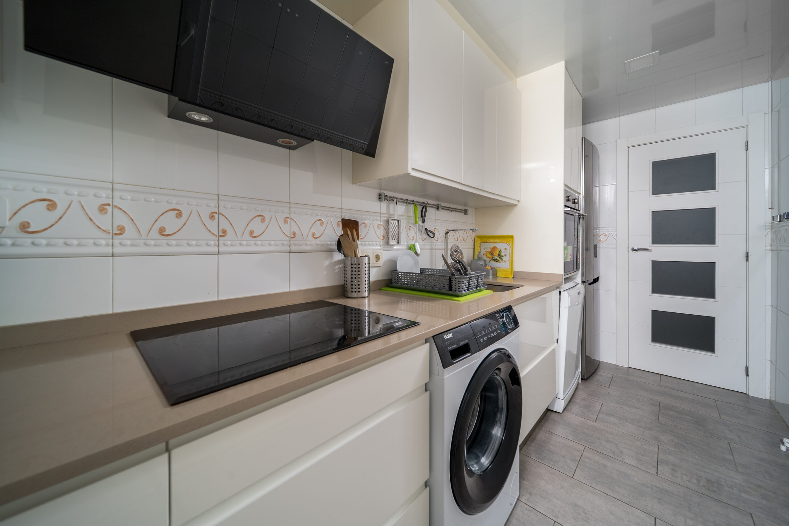 a kitchen with white cabinets and appliances